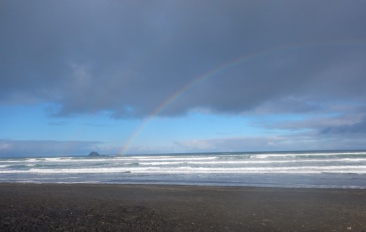 Beautiful rainbow over a black sand beach